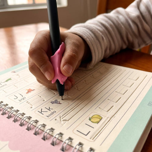 Mano de niña escribiendo dentro del surco de la hoja
